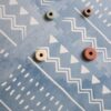 Niebieska mata piankowa puzzle Olya Kids - Drewniane zabawki na niebieskiej macie piankowej z białymi wzorami Boho