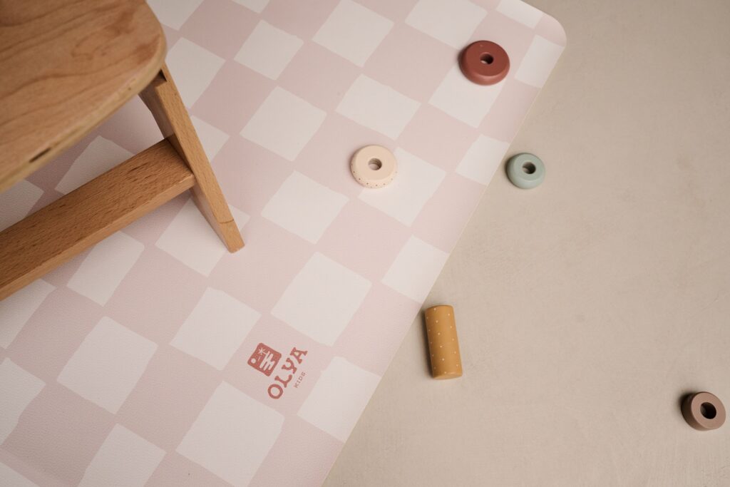 Splashmat Mata ochronna Pink Beige - Wodoodporna mata ochronna dla dzieci, idealna do użytku pod krzesełkiem do karmienia podczas rozszerzania diety oraz podczas zabaw kreatywnych, takich jak malowanie farbami czy zabawy piaskiem kinetycznym. Wykonana z nietoksycznej, wegańskiej skóry, zapewniająca łatwe utrzymanie czystości i stabilność dzięki antypoślizgowemu spodowi. Idealna do domu, dostępna w dwóch kształtach: okrąg o średnicy 110 cm oraz prostokąt 95×125 cm, w unikalnym wzornictwie CHESS PINK BEIGE.