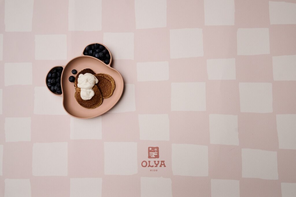 Splashmat Mata ochronna pod krzesełko Pink Beige - Wodoodporna mata ochronna dla dzieci, idealna do użytku pod krzesełkiem do karmienia podczas rozszerzania diety oraz podczas zabaw kreatywnych, takich jak malowanie farbami czy zabawy piaskiem kinetycznym. Wykonana z nietoksycznej, wegańskiej skóry, zapewniająca łatwe utrzymanie czystości i stabilność dzięki antypoślizgowemu spodowi. Idealna do domu, dostępna w dwóch kształtach: okrąg o średnicy 110 cm oraz prostokąt 95×125 cm, w unikalnym wzornictwie CHESS PINK BEIGE.